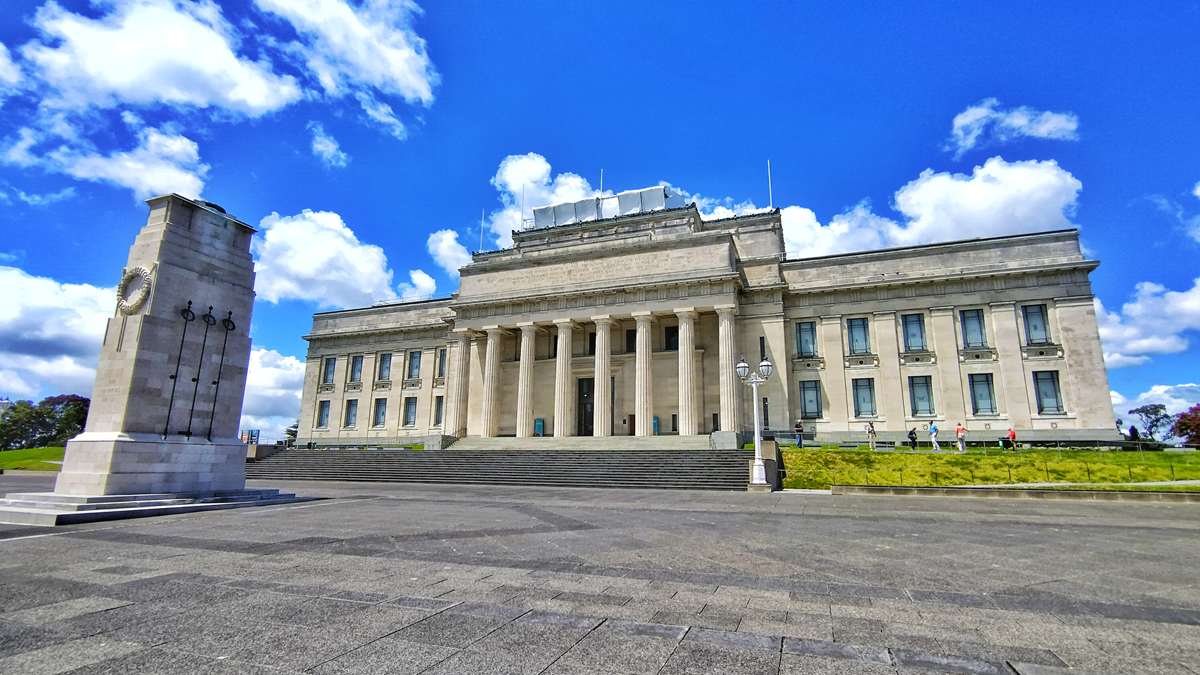 Das neoklassizistische Auckland War Memorial Museum mit dem davor stehenden Kenotaph-Kriegsdenkmal unter blauem Himmel
